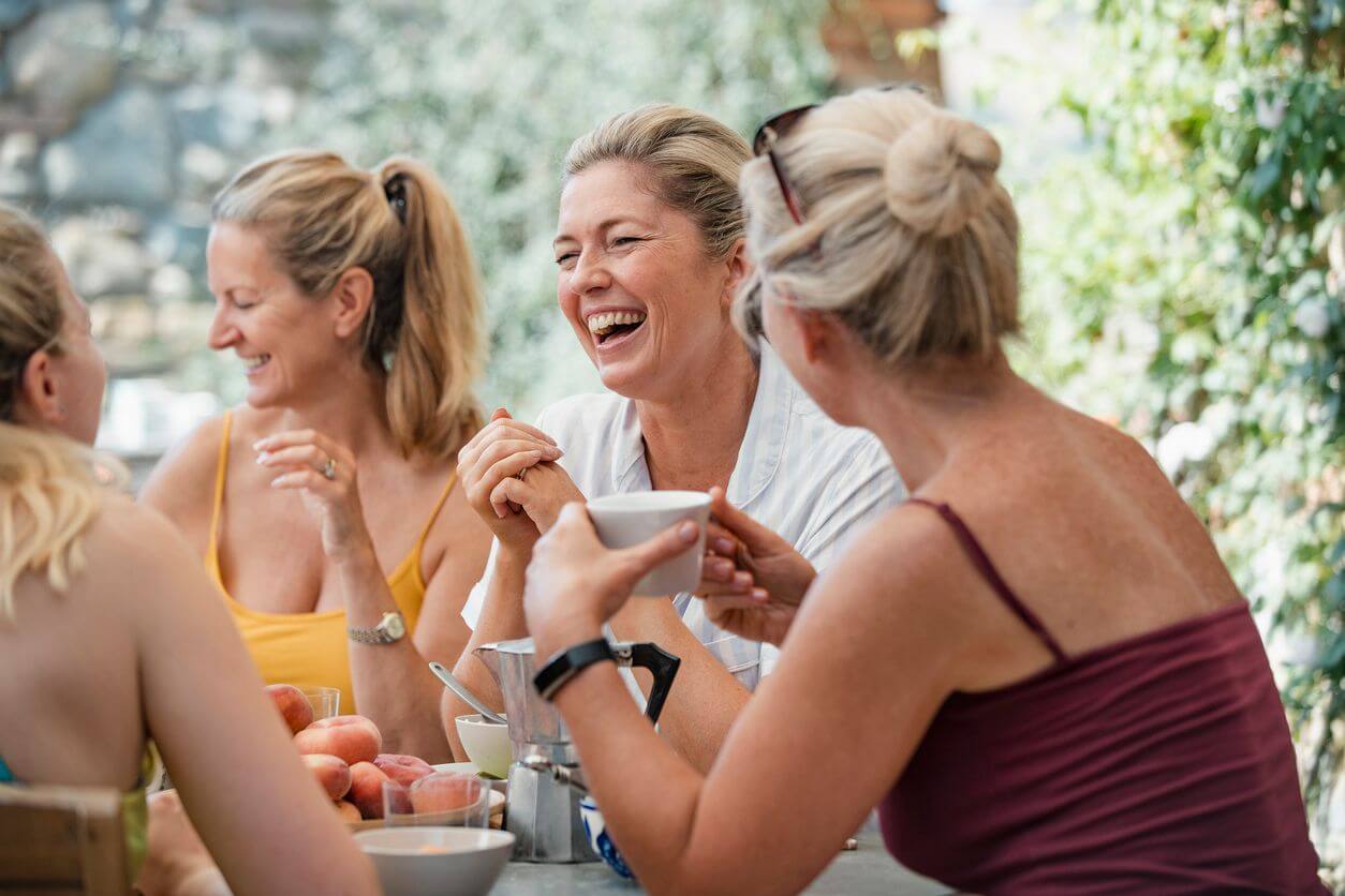 women laughing at lunch table how to start over at 50