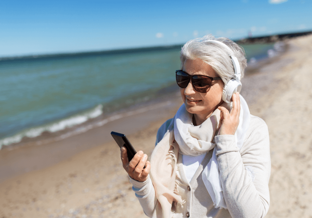 senior woman listening to something podcasts for women over 50