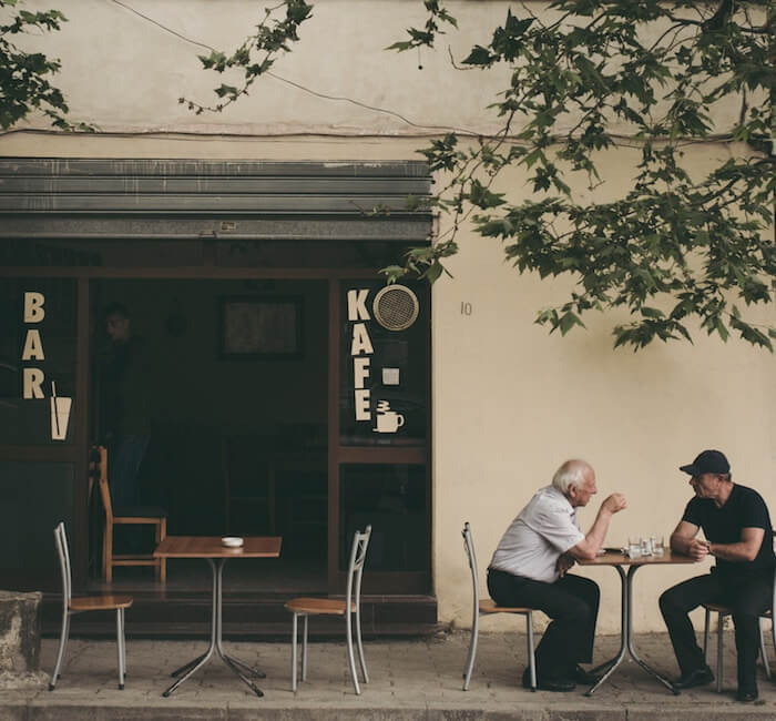 两个男人坐在咖啡桌旁交谈，心领神会