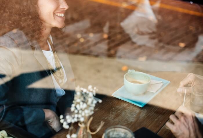 坐在咖啡的妇女微笑在日期第一个日期问题