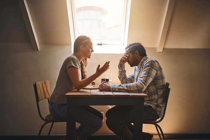 男人和女人坐在桌旁谈论情感虐待的影响