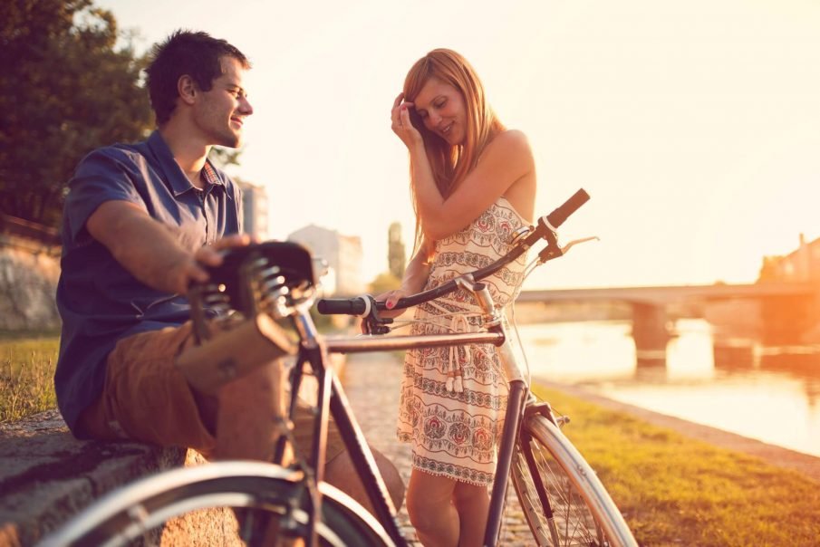 夫妇在自行车上，签署一个女孩喜欢你，但正在努力不要展示它