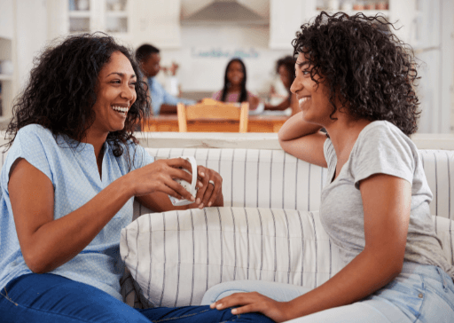 women sitting on sofa laughing how to be a good listener