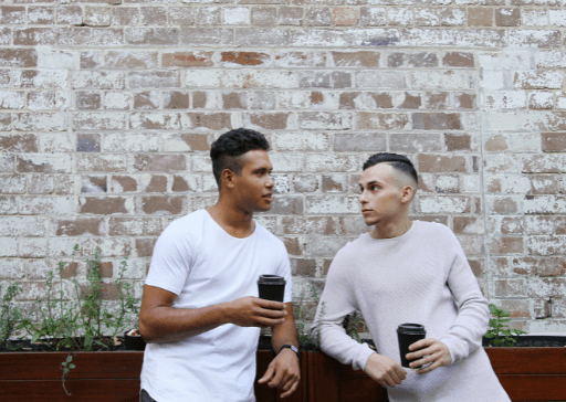 men standing by brick wall talking how to be a good listener