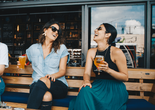 woman laughing drinking beer outside get to know you questions