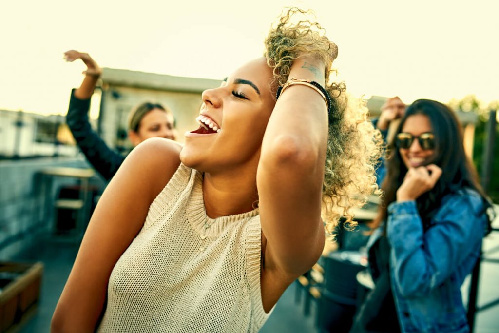 woman dancing outdoors how to make friends in a new city