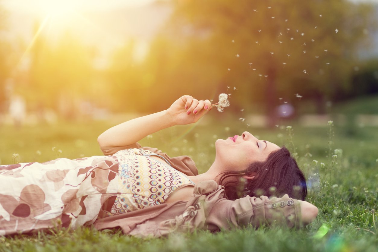 relaxed woman blowing dandelion, types of empaths