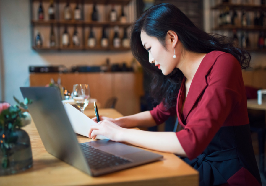 在餐厅用笔记本电脑工作的女人具有勤奋性格的特点