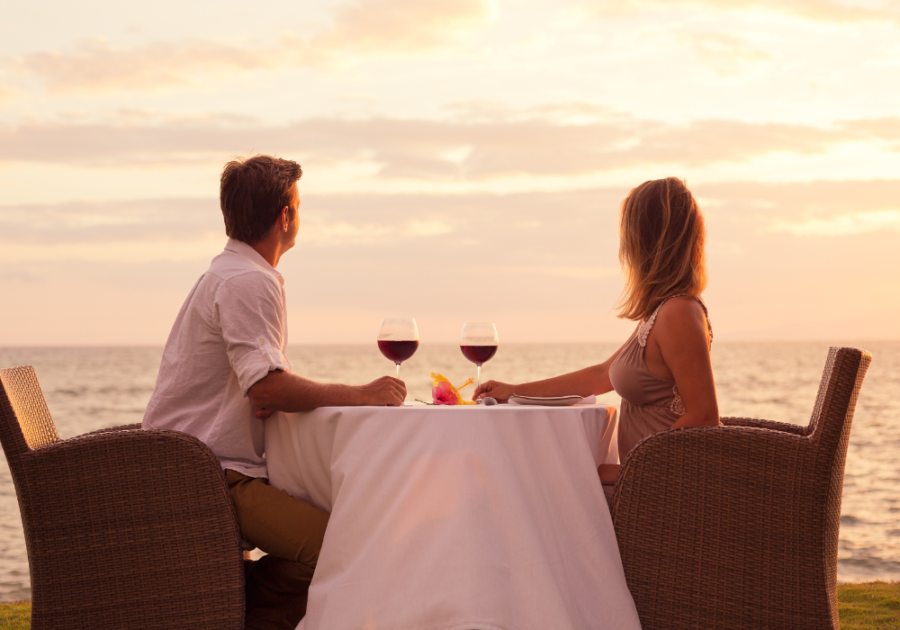 couple sitting by ocean drinking wine date romantic thing to do for your wife