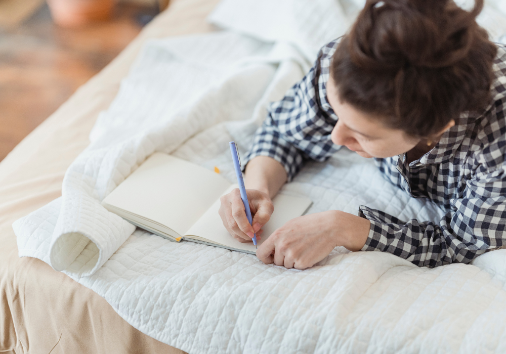 一个穿着睡衣的女人在日记里写着个人成长日记提示