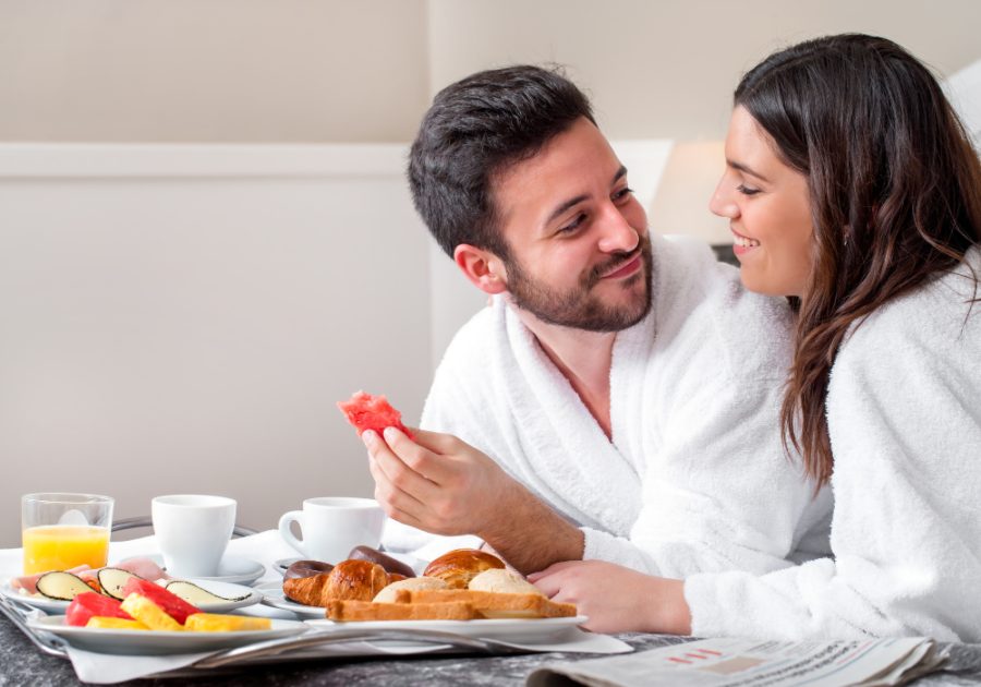 穿着长袍的夫妇吃早餐浪漫的酒店房间给她的想法