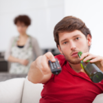 man drinking bottled drink while holding the remote deadly signs of an immature man