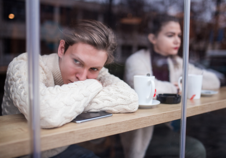 man in a coffee shop looking unhappy signs hes hurting after the break up