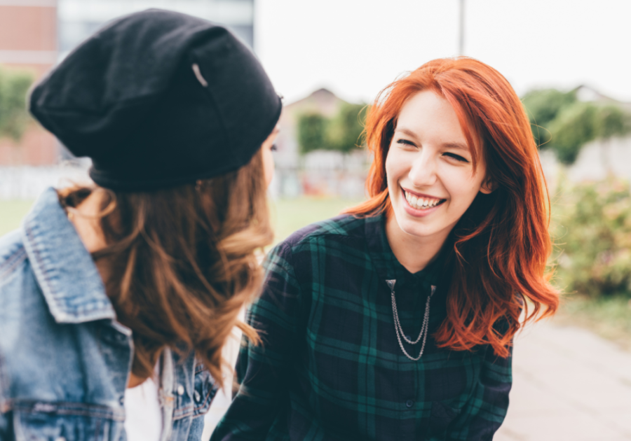 women smiling sitting outdoors Beta Female Traits