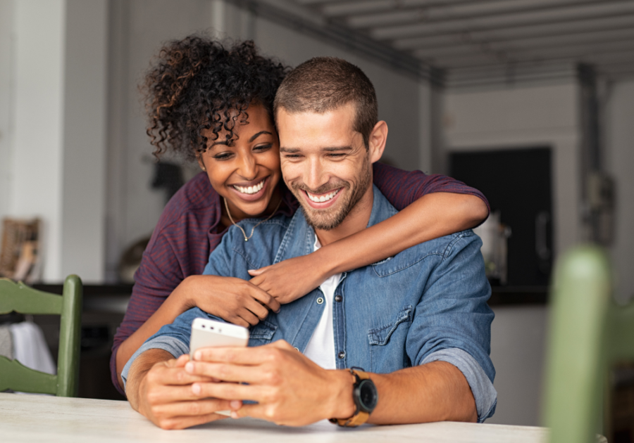 woman hugging man while looking at phone emotional birthday wishes for boyfriend