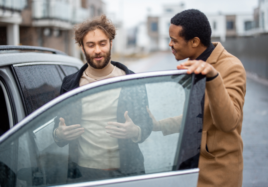 two men talking outside the car signs a guy is pretending to be straight