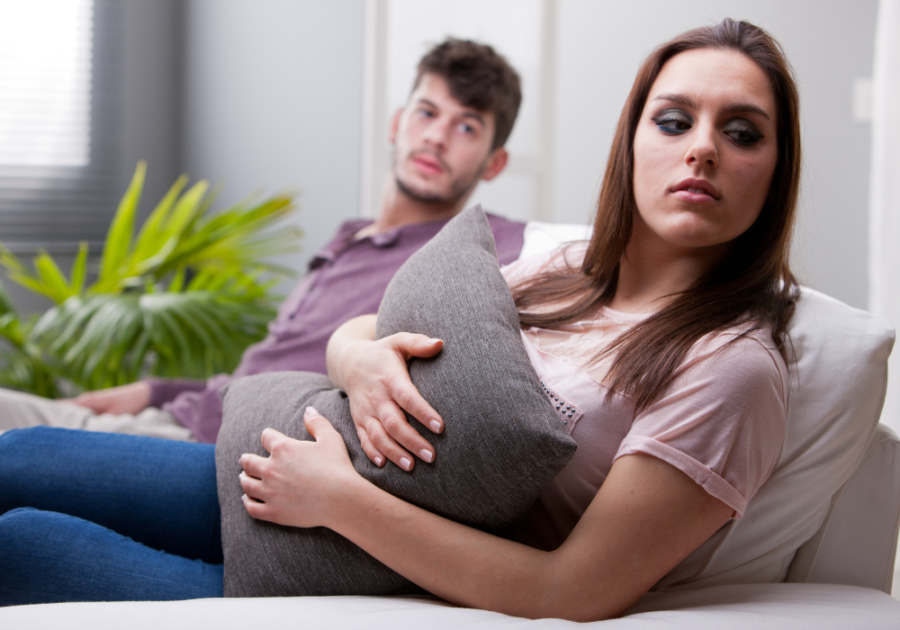 couple sitting on sofa Signs She Is Pretending To Love You