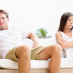 couple sitting on sofa unhappy Signs of Emotional Neglect in a Marriage