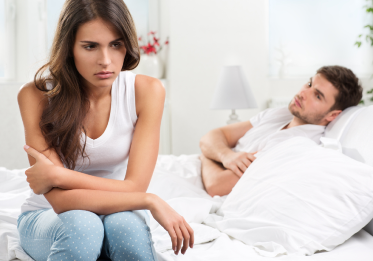 man in bed woman sitting on side of bed When To Walk Away From A Sexless Marriage