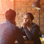 couple sitting at table signs of Unintentional Gaslighting