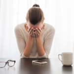 woman hands on face at desk introvert hangover