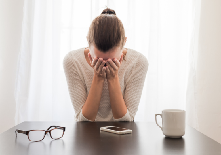 女人在办公桌前把手放在脸上内向宿醉