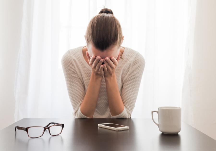woman hands on face at desk introvert hangover