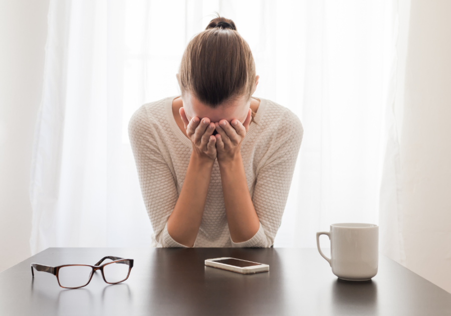 女人双手捂着脸坐在桌子上内向的宿醉