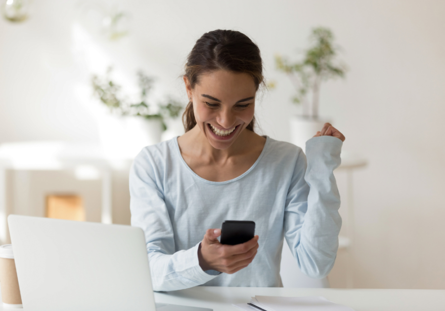 woman smiling looking at phone Best Tinder Bios for Guys