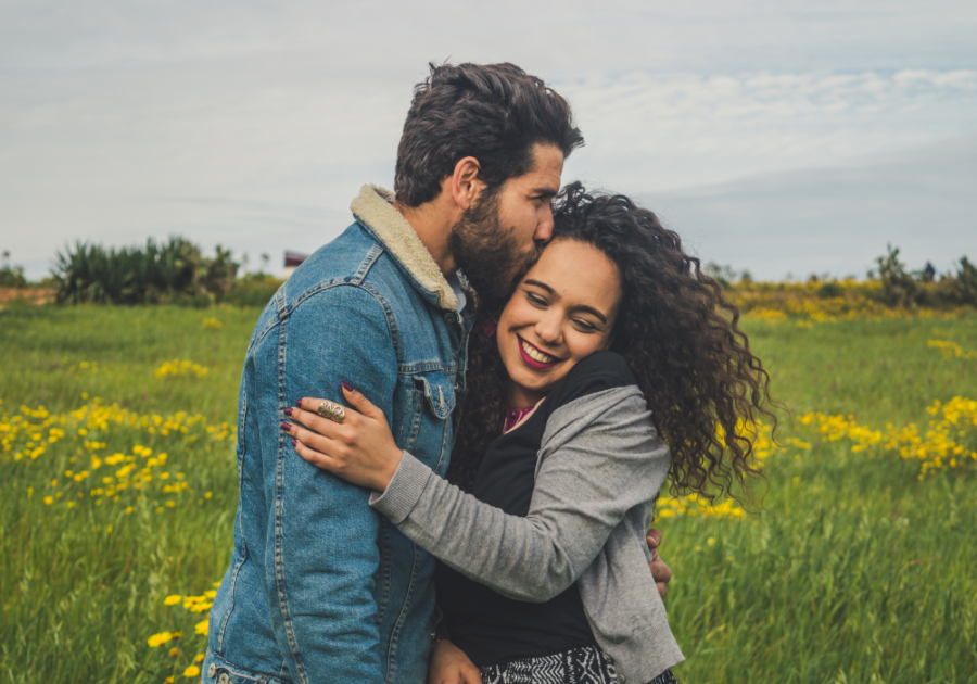 couple hugging in flower field Cancer Man and Leo Woman Compatibility