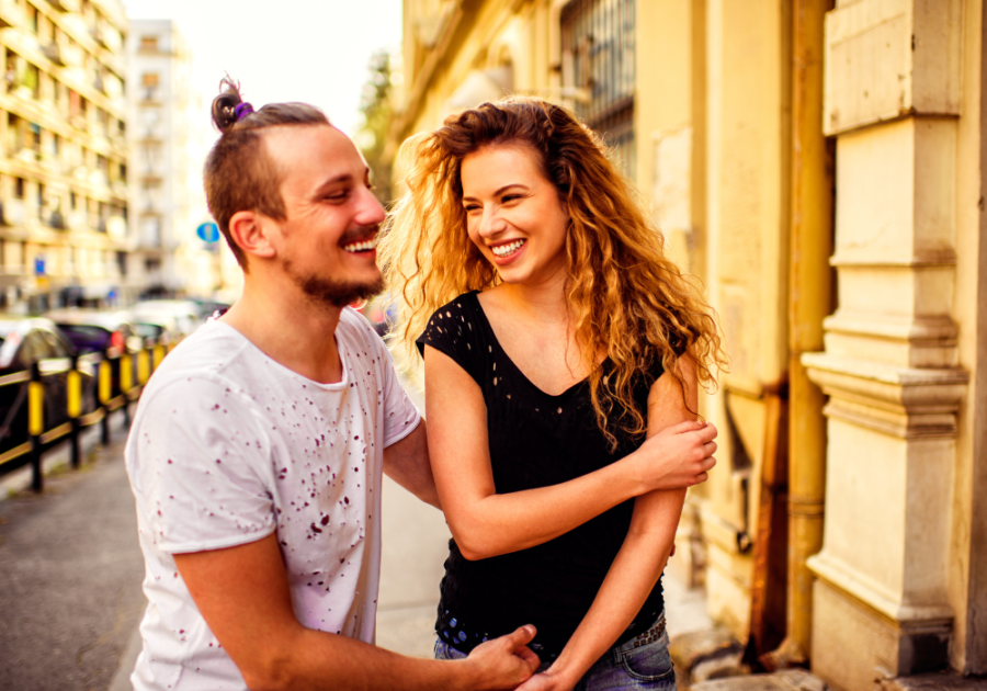 couple laughing on street Cancer Man and Leo Woman Compatibility