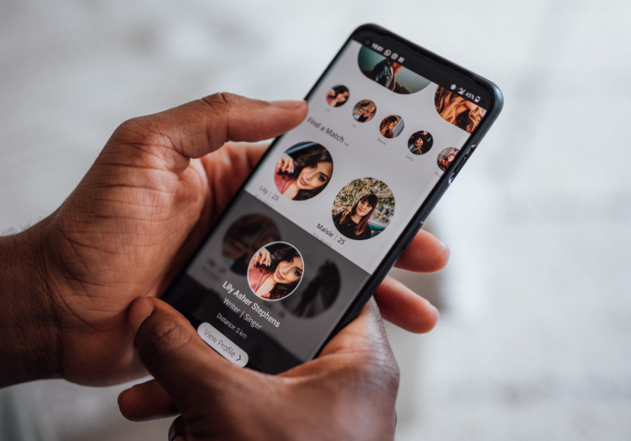 person holding phone and looking at profiles start a conversation on Tinder