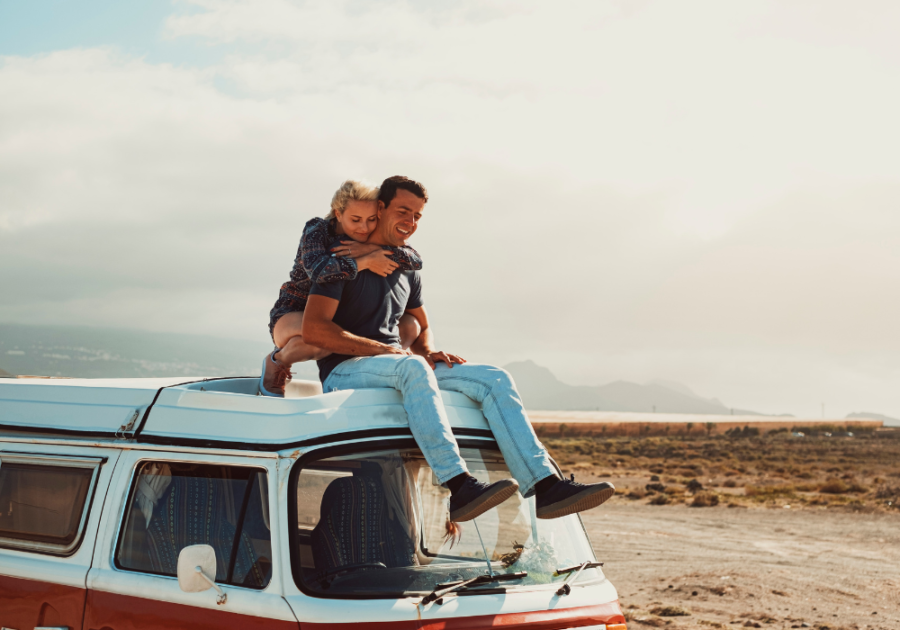 couple sitting on top of van hugging in desert Best Matches for an Aries Woman