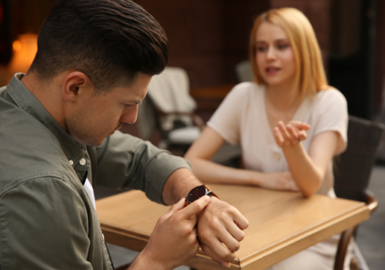man looking at watch woman is talking how To Stop Talking So Much