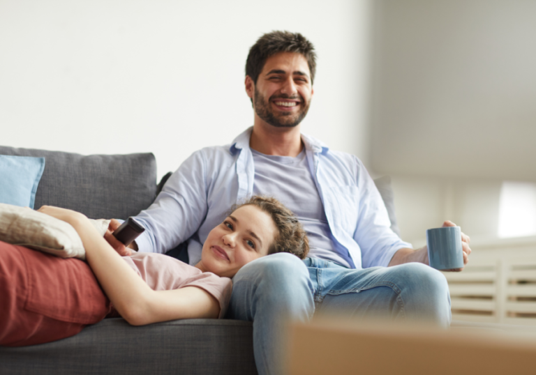 couple sitting on sofa watching tv movies to watch with your boyfriend