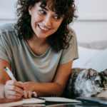woman smiling writing note Cute Notes to Write Your Boyfriend