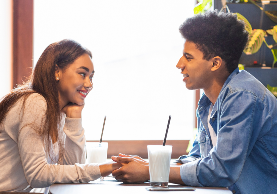 couple holding hands at table Couple Questions Game