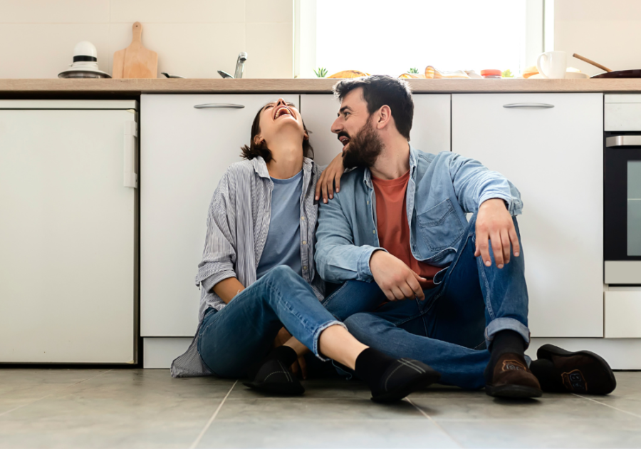 couple sitting on kitchen floor laughing Couple Questions Game