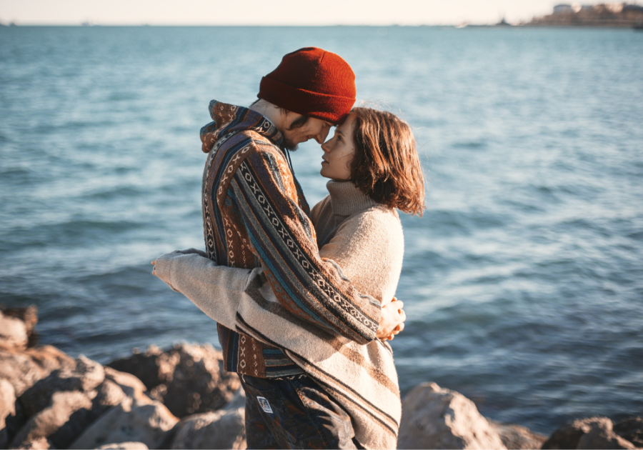 couple standing by ocean Signs of an Aries Man in Love