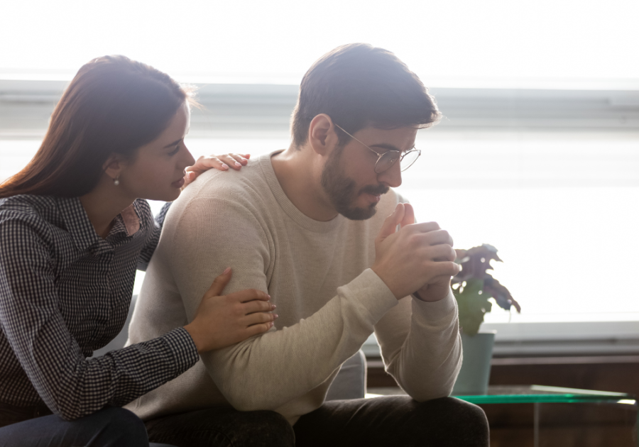 couple sitting together woman is consoling man Power Dynamics in Relationships