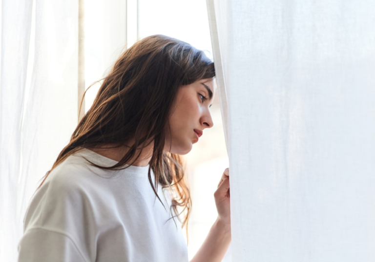 woman sadly looking out window How to Get Over Someone You Love