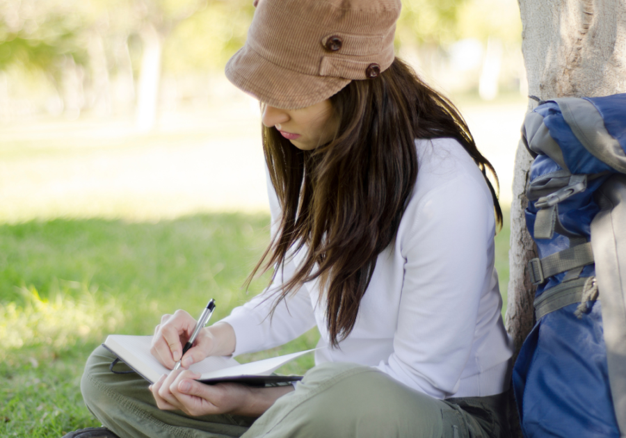 woman sitting by tree writing How to Emotionally Detach from Someone