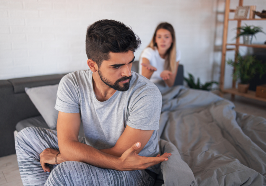 man sitting on sofa with woman behind him  Falling Out of Love After Infidelity