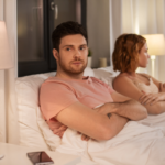 couple sitting in bed with arms crossed How Long Is Too Long Without Sex in a Relationship
