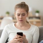 woman looking at phone sitting down did he block you because he cares