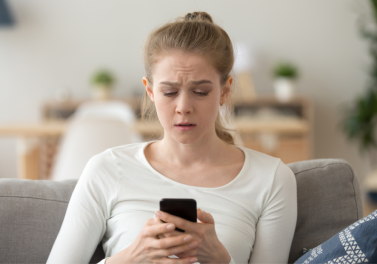 woman looking at phone sitting down did he block you because he cares