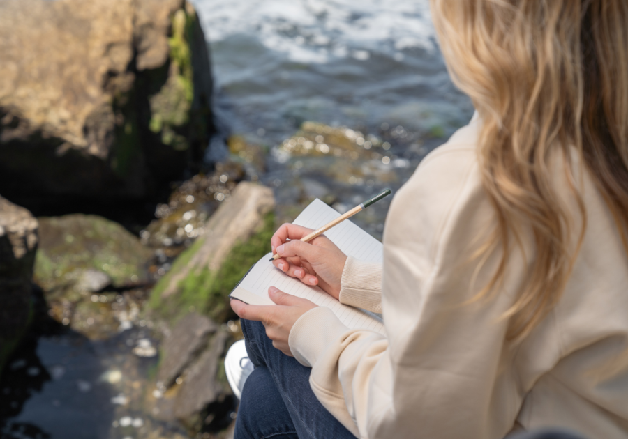 woman writing outdoors Stop Wanting a Relationship So Badly