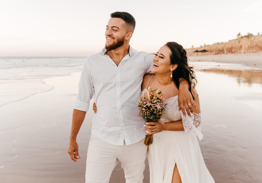 couple on beach smiling hugging Funny Marriage Advice for Newlyweds