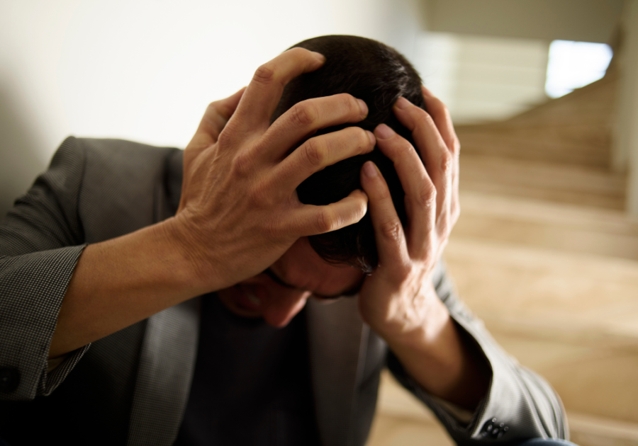 man holding his head looking downward Sympathy Messages for the Loss of a Mother