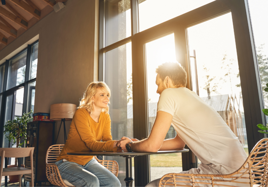 couple sitting at table holding hands 3 Words to Make a Woman Want You